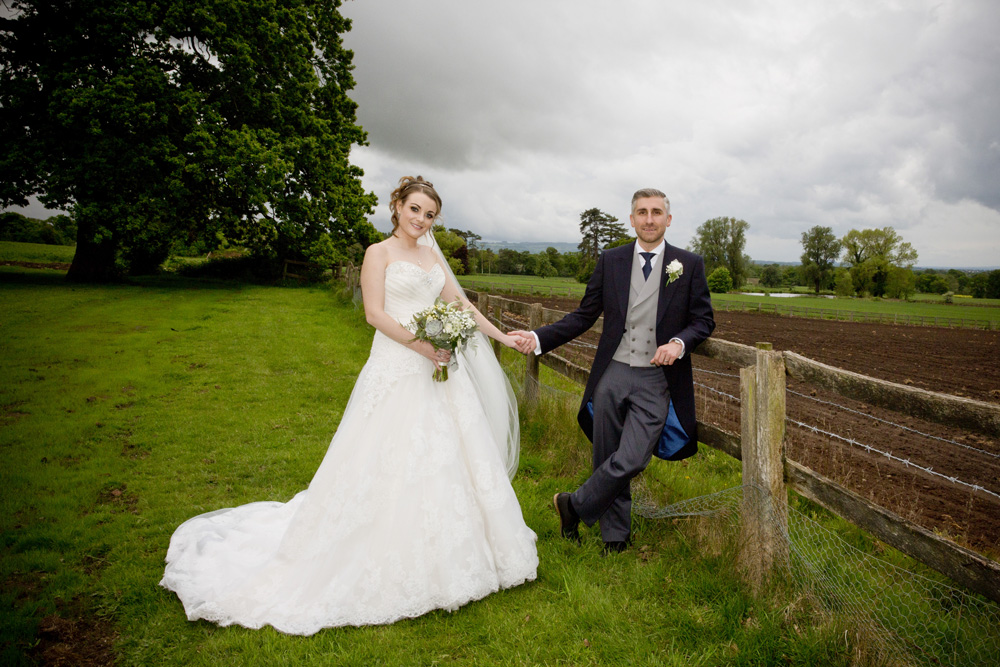 wedding photographer image of bride and groom standing in a field