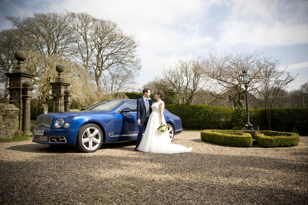 wedding photographer image of bride and groom standing next to car