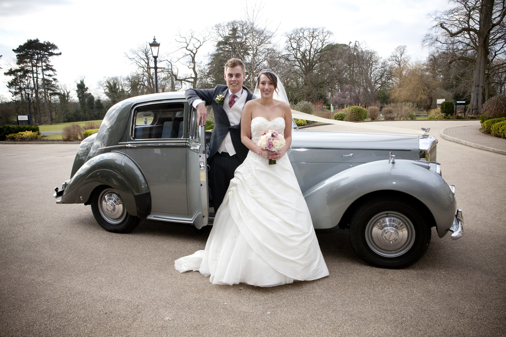 wedding photographer image of bride and groom standing by a wedding car at Rookery Hall, Nantwich