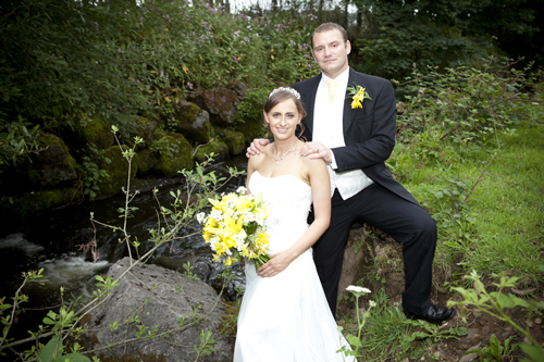 wedding photographer image of bride and groom standing by stream