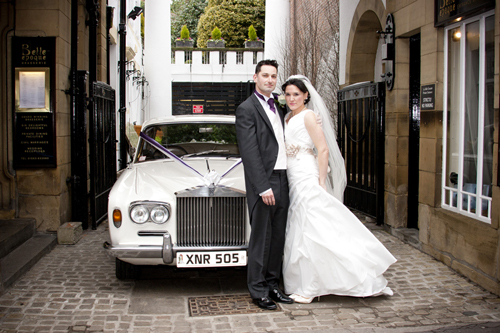 wedding photographer image of bride and groom standing by wedding car