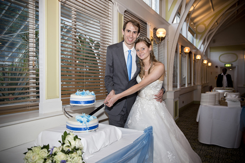 wedding photographer image of bride and groom standing by wedding cake
